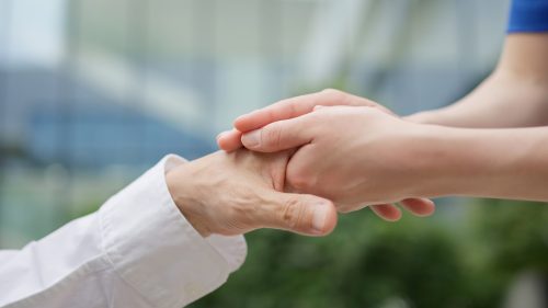 Caregiver's hands reaching out to the elderly